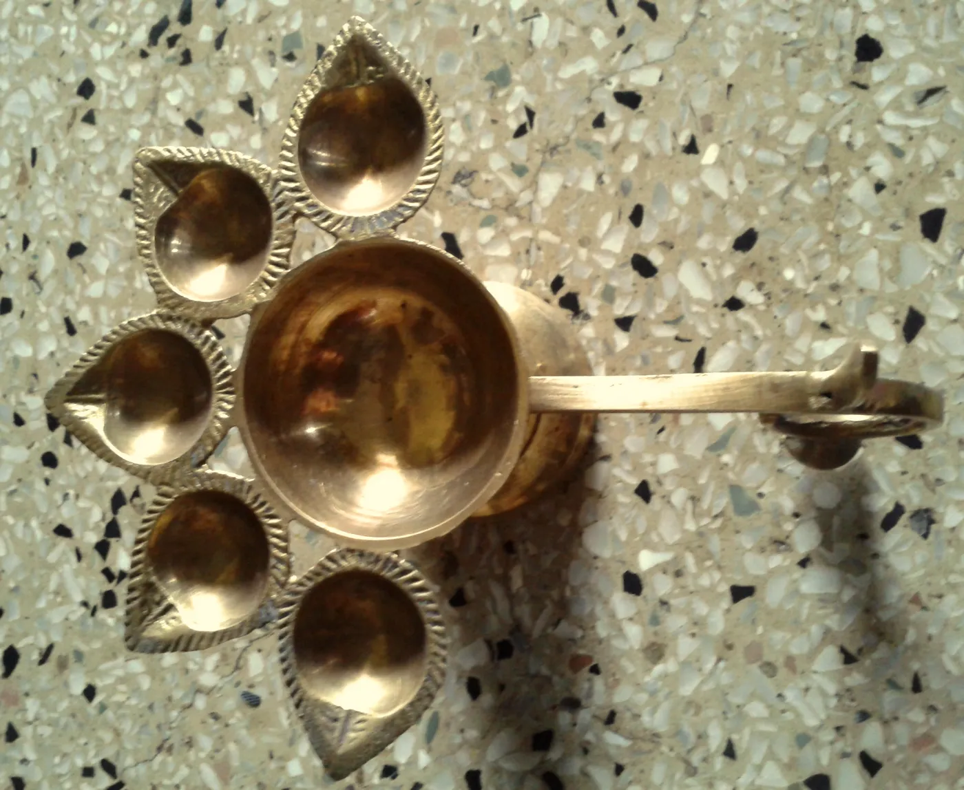A five-wick brass aarti diya with a long handle