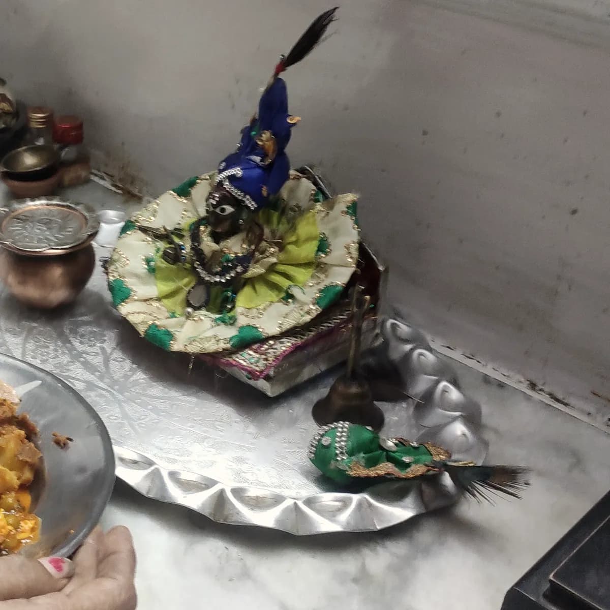 Laddu Gopal on a silver thali, as a bhog of puri and sweets is offered