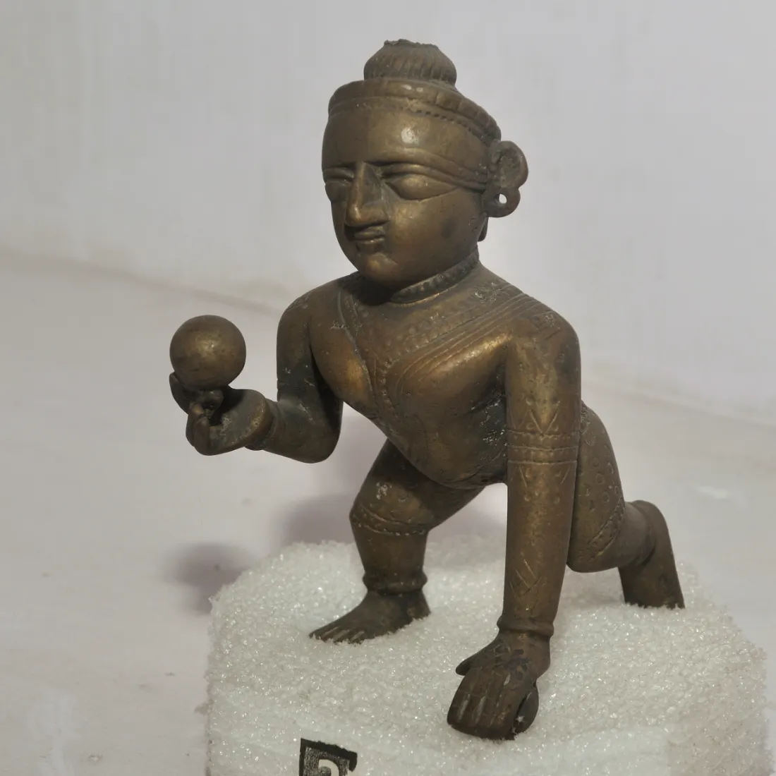 A bronze figure of Bal Krishna crawling with a sweet in his hand, Government Museum, Mathura