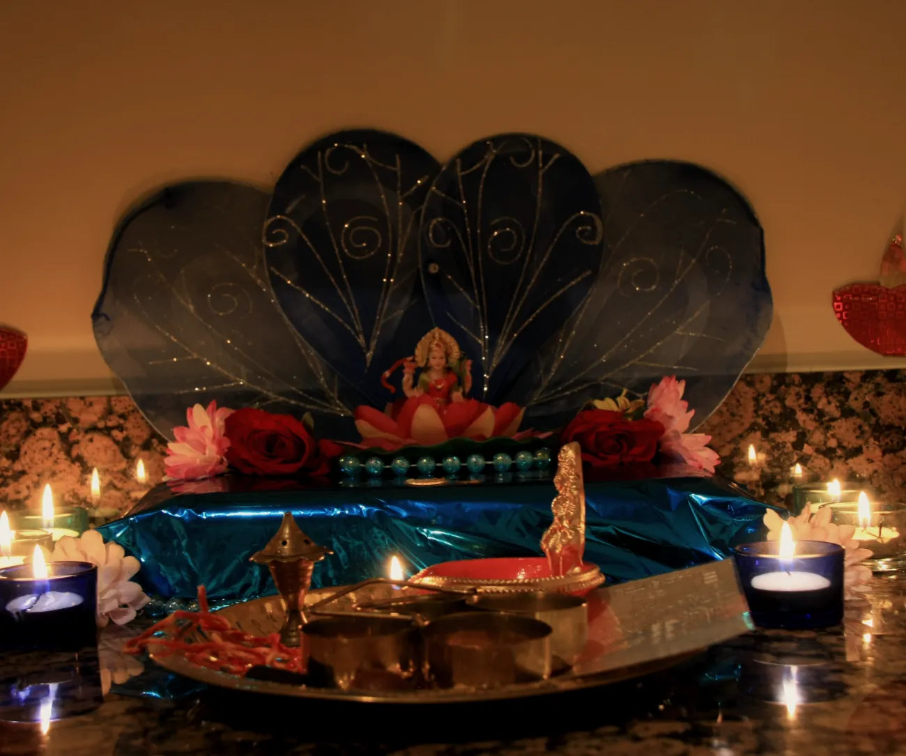 A home altar for Lakshmi puja on Diwali, lit with small lamps and flowers