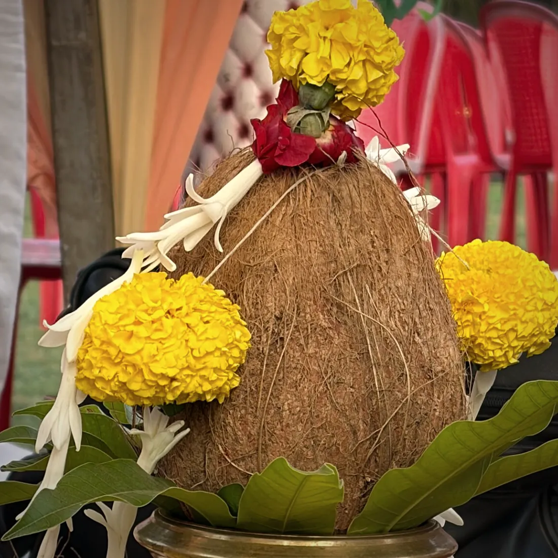 A coconut kalash wrapped in yellow thread with marigolds, prepared for a wedding